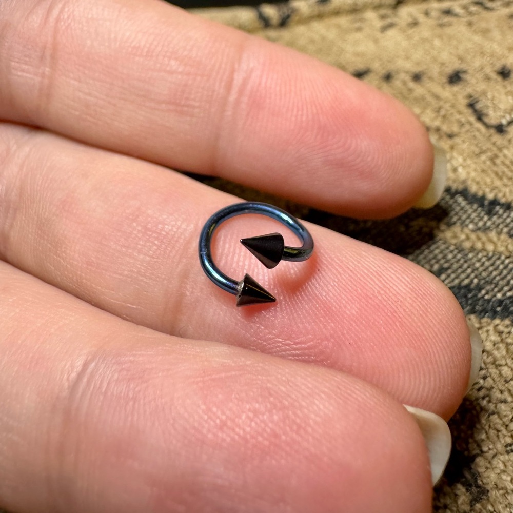 Anodized blue twist piercing with black spikes.